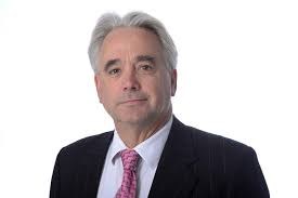 Head and shoulders picture of Dr Peter Holloway smiling and wearing a suit and tie