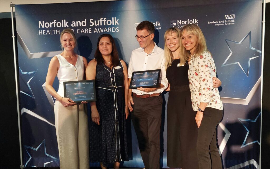 Michaela Strachan with award winners holding a certificate