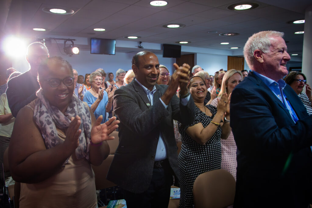 People on their feet, looking happy and clapping at the awards ceremony