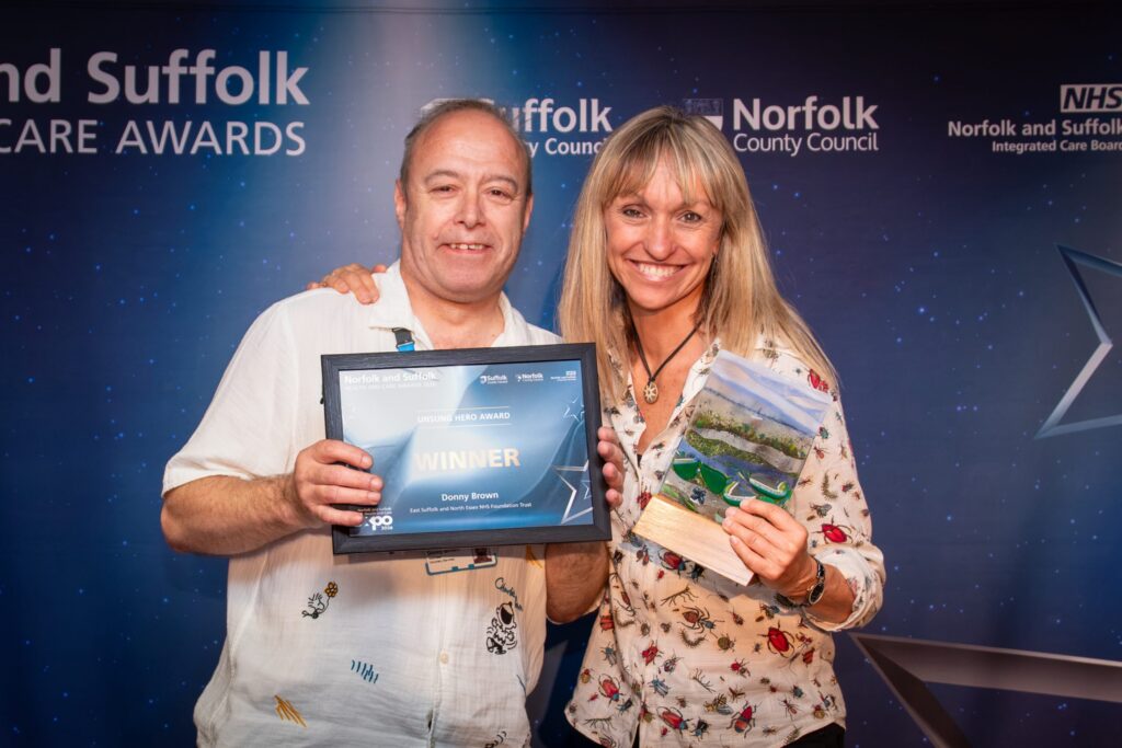 Donny Brown holding his certificate with Michaela Strachan holding the award