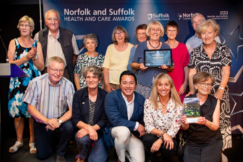 13 people from Botesdale Health Centre and partners holding their certificate and award with Michaela Strachan