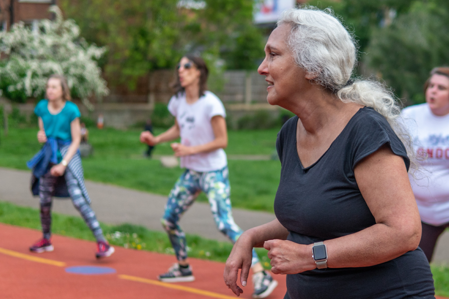 A group of women in sportwear are facing the same direction. They seem to be in an exercise class.