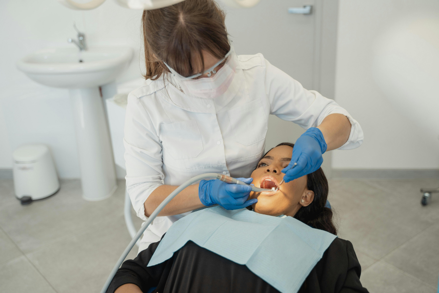 A dentist in PPE is working on a patient